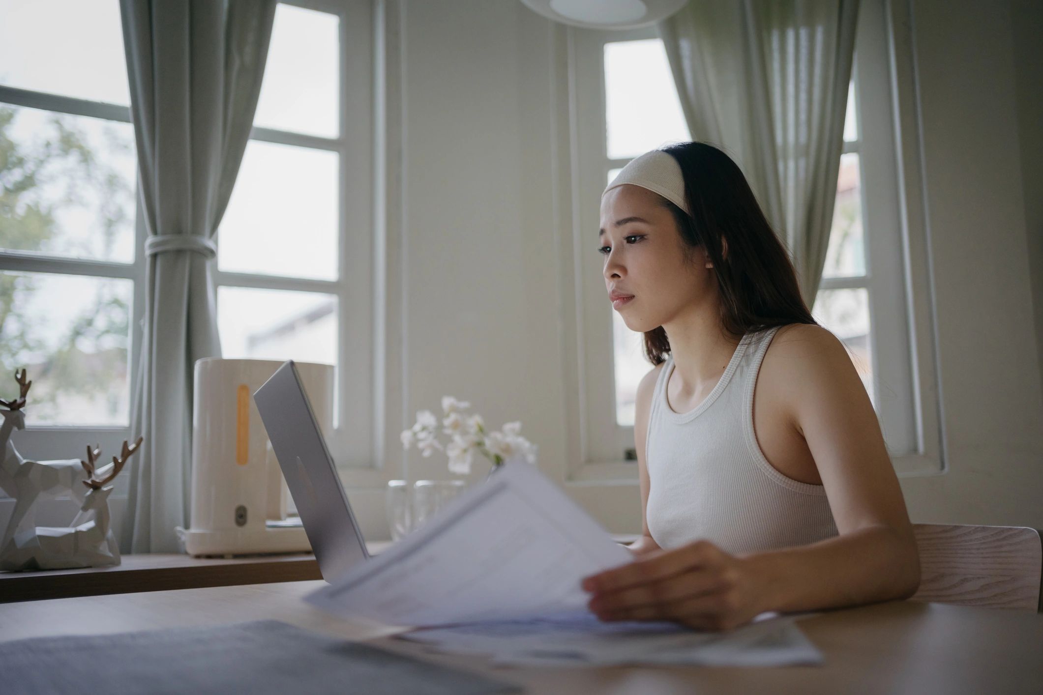 Person working on a laptop while reviewing financial information