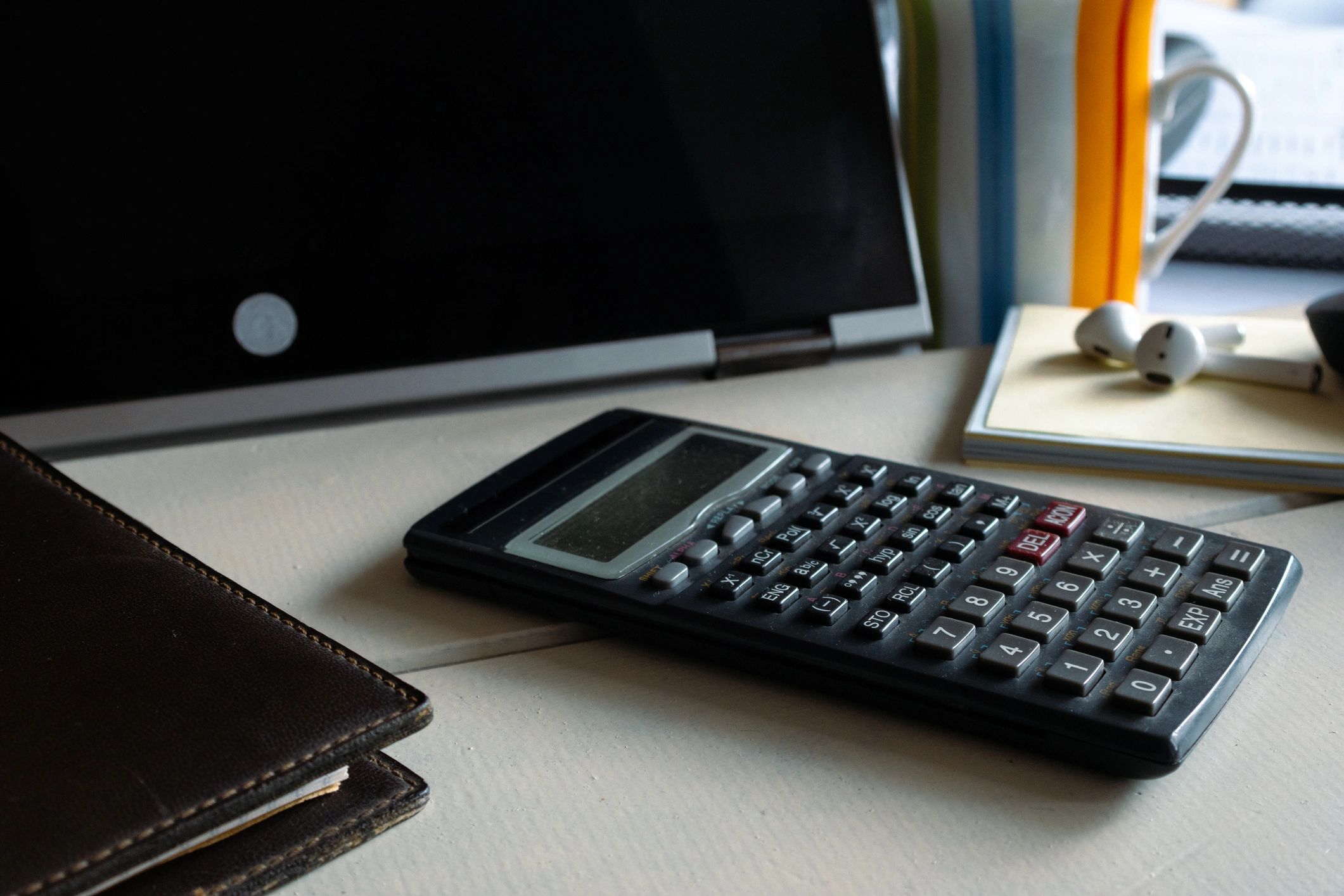 Desk with calculator, notebook, and laptop for personal finance planning
